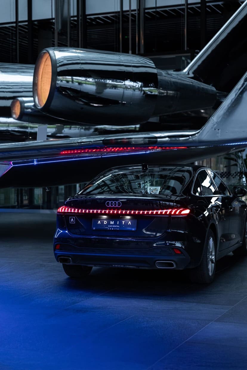 Juodas Audi automobilis su Admita logotipu prie modernaus verslo centro pastato | ADMITA