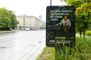 ADMITA reklaminis stendas Vilniuje, kviečiantis fotografuoti įmonės automobilius ir laimėti 1000 eurų